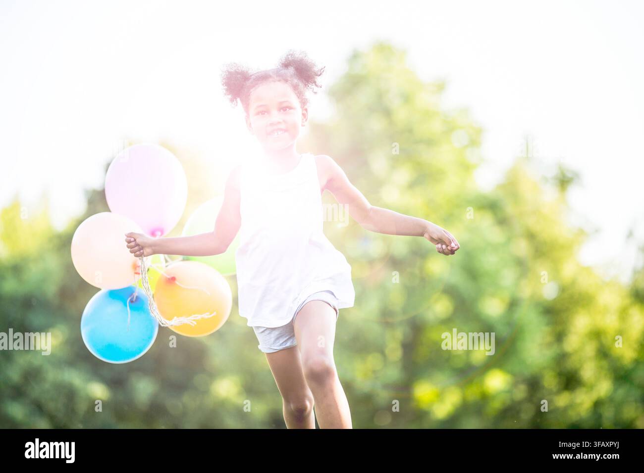 Fille courir avec des ballons. Banque D'Images