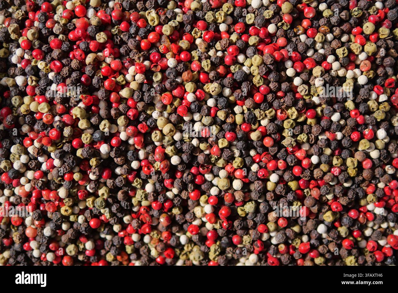 Mélange coloré de différents grains de poivre sur une surface Banque D'Images
