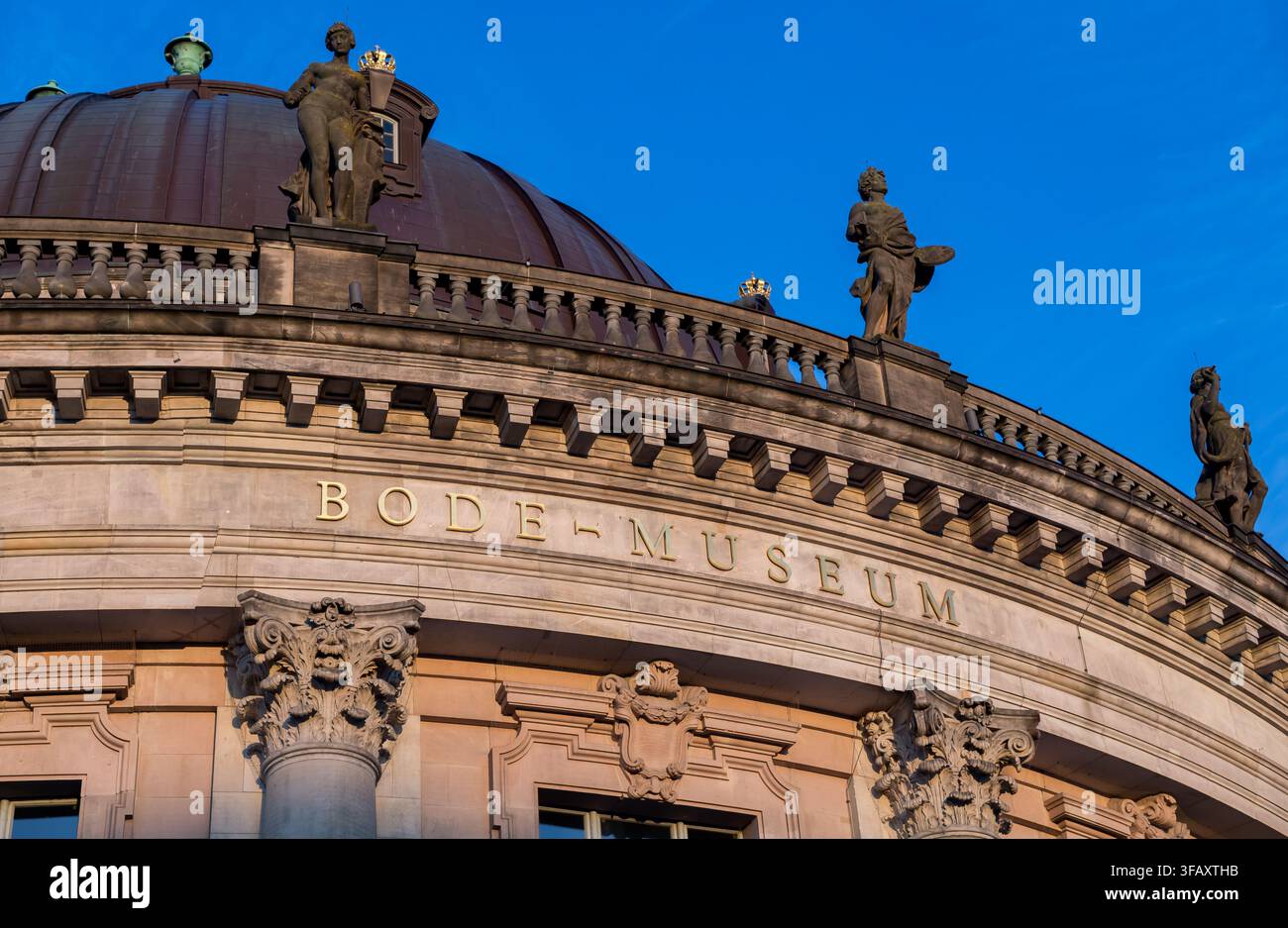 Détail architectural du musée historique Bode avec son nom gravé dans la façade en pierre, des colonnes décoratives, un dôme et des statues sur le toit. Banque D'Images