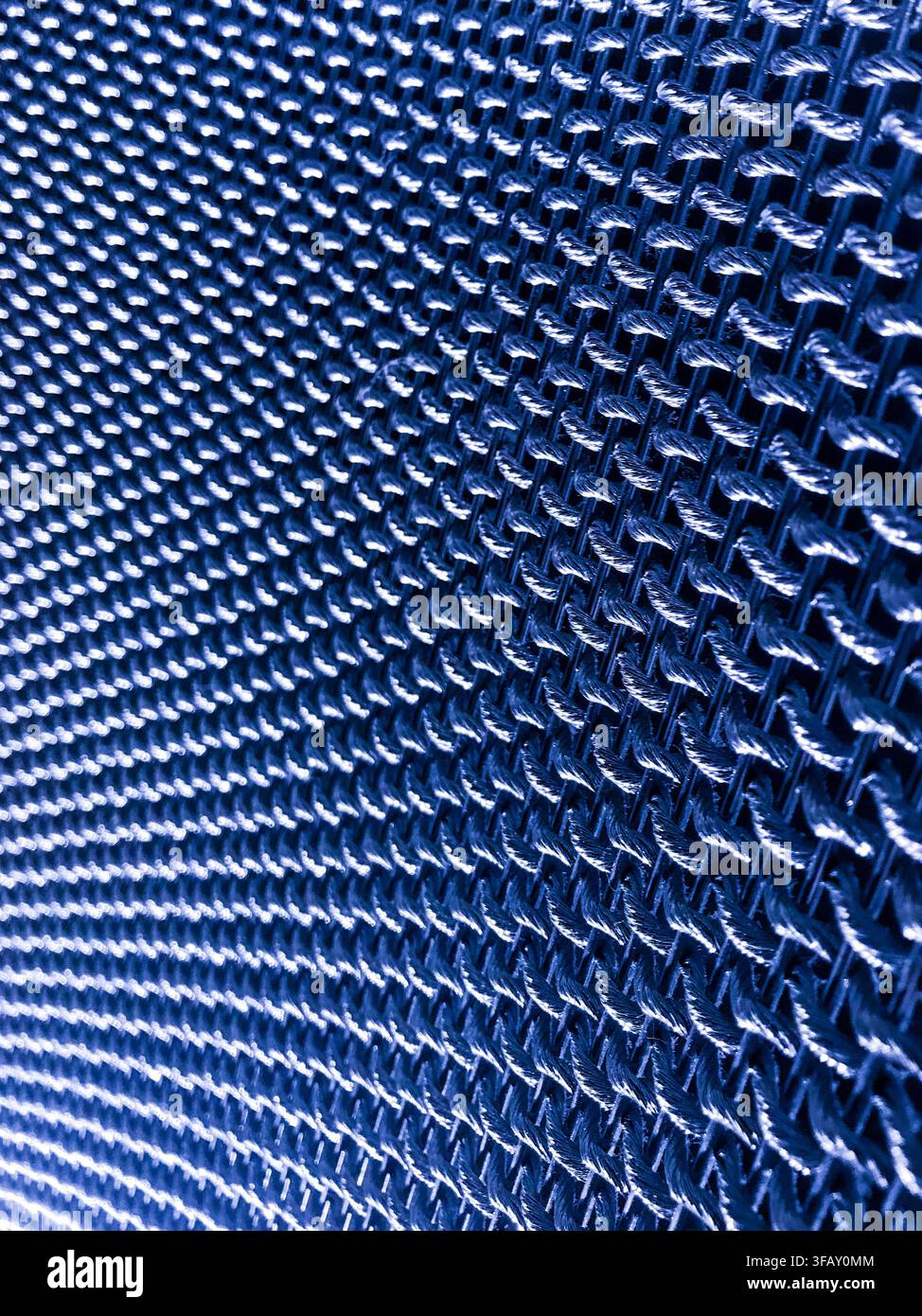 Macro d'une texture de tissu tissé bleu avec un motif de grille répétitif, fond géométrique abstrait pour la technologie ou le design industriel. Banque D'Images