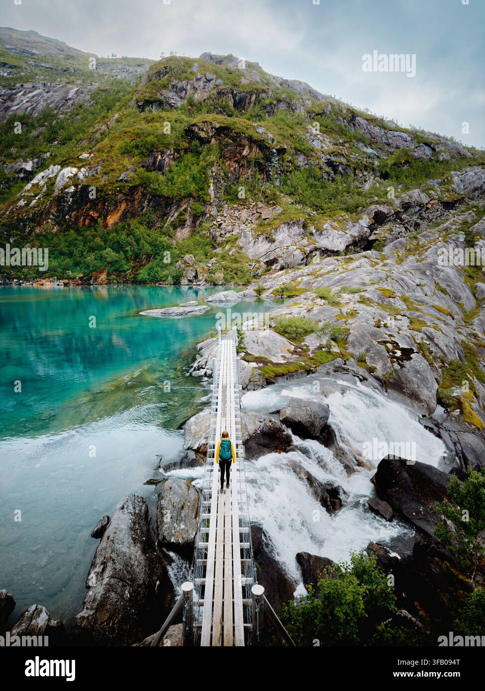 Voyage en Norvège - femme randonnant seule dans les montagnes de Rago traversant un pont au-dessus d’une cascade et d’un lac, mode de vie sain, liberté, aventure active, vacances d’été Banque D'Images