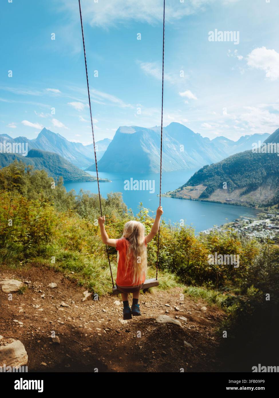Petite fille se balançant avec vue sur le fjord et les montagnes, voyage en famille en Norvège, enfant s'amusant lors de vacances actives en plein air, randonnée, aventure en Su Banque D'Images