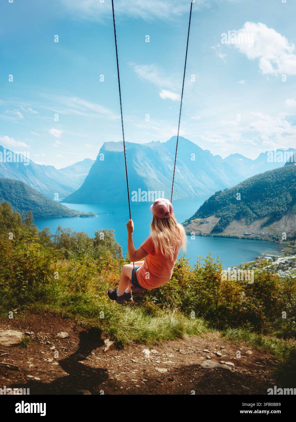 Touriste femme voyageant en Norvège en se balançant avec vue sur les fjords et les montagnes, jeune voyageuse profitant de vacances actives en plein air, randonnée, aventure en tournée à Sunn Banque D'Images