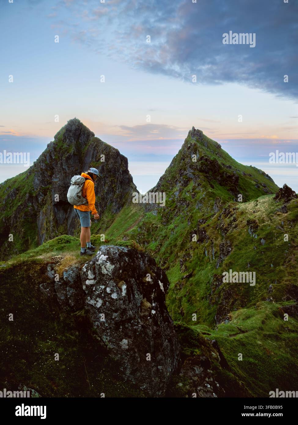 Homme randonneur escaladant des montagnes en voyage solo en Norvège, mode de vie sain, aventure active, vacances d'été, tournée en plein air, touriste backpacker debout sur un rocher Banque D'Images