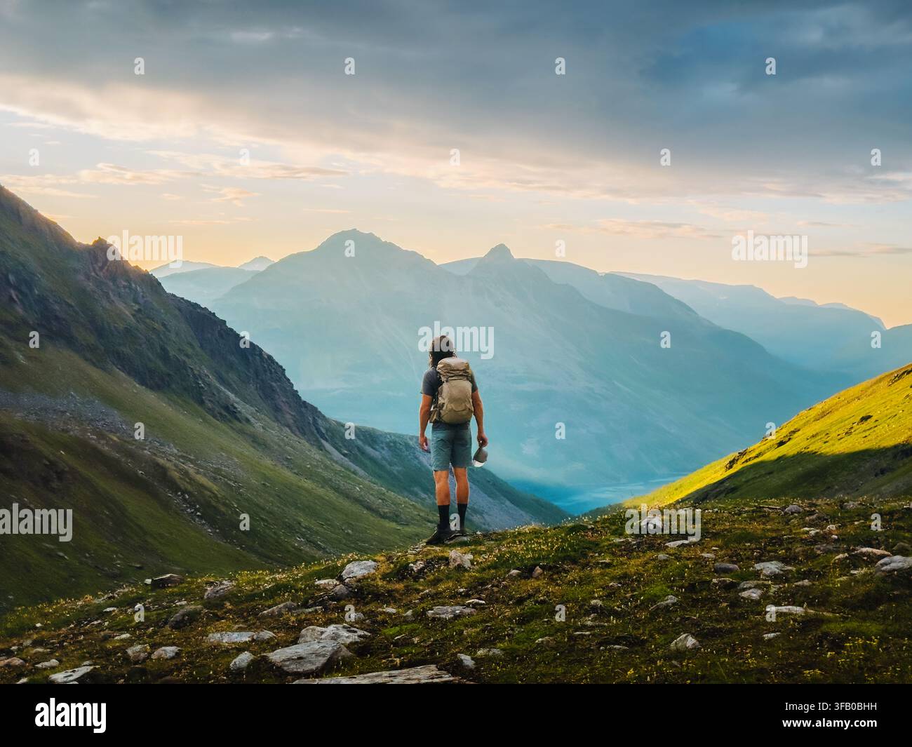 Voyageur masculin escaladant des montagnes en solo en Norvège, mode de vie sain, aventure active, vacances d'été, tournée, plein air, touriste backpacker profitant de Ly Banque D'Images