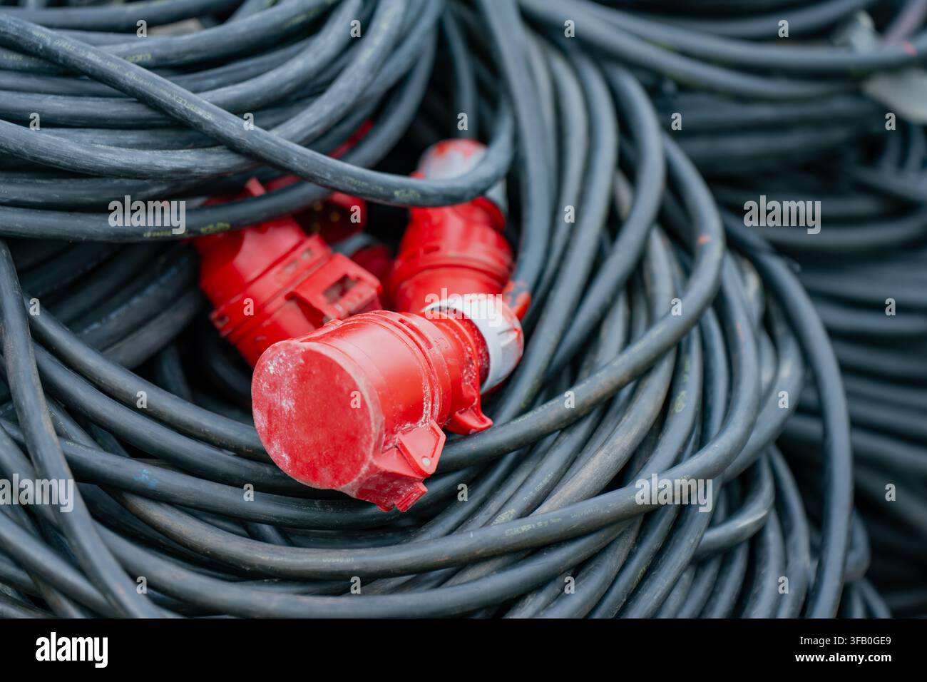 Rouleau de câble d'alimentation triphasé industriel avec connecteur à prise robuste rouge pour la distribution temporaire d'énergie haute tension Banque D'Images