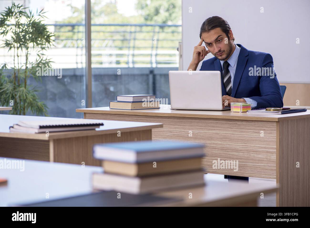 Jeune enseignante en costume dans la classe Banque D'Images