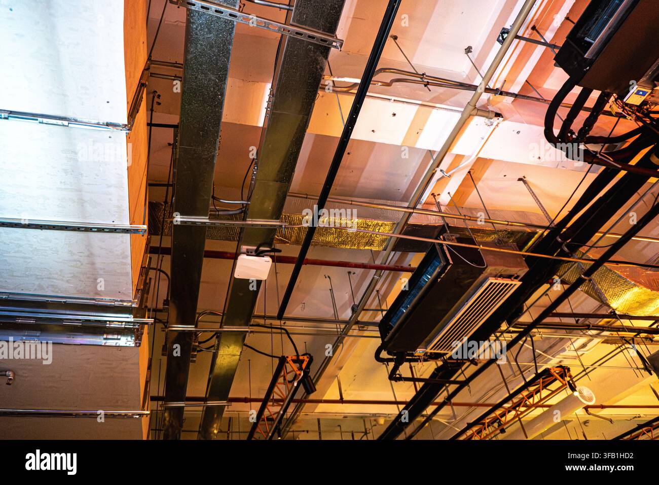 Plafond industriel avec tuyaux et conduits exposés. Banque D'Images