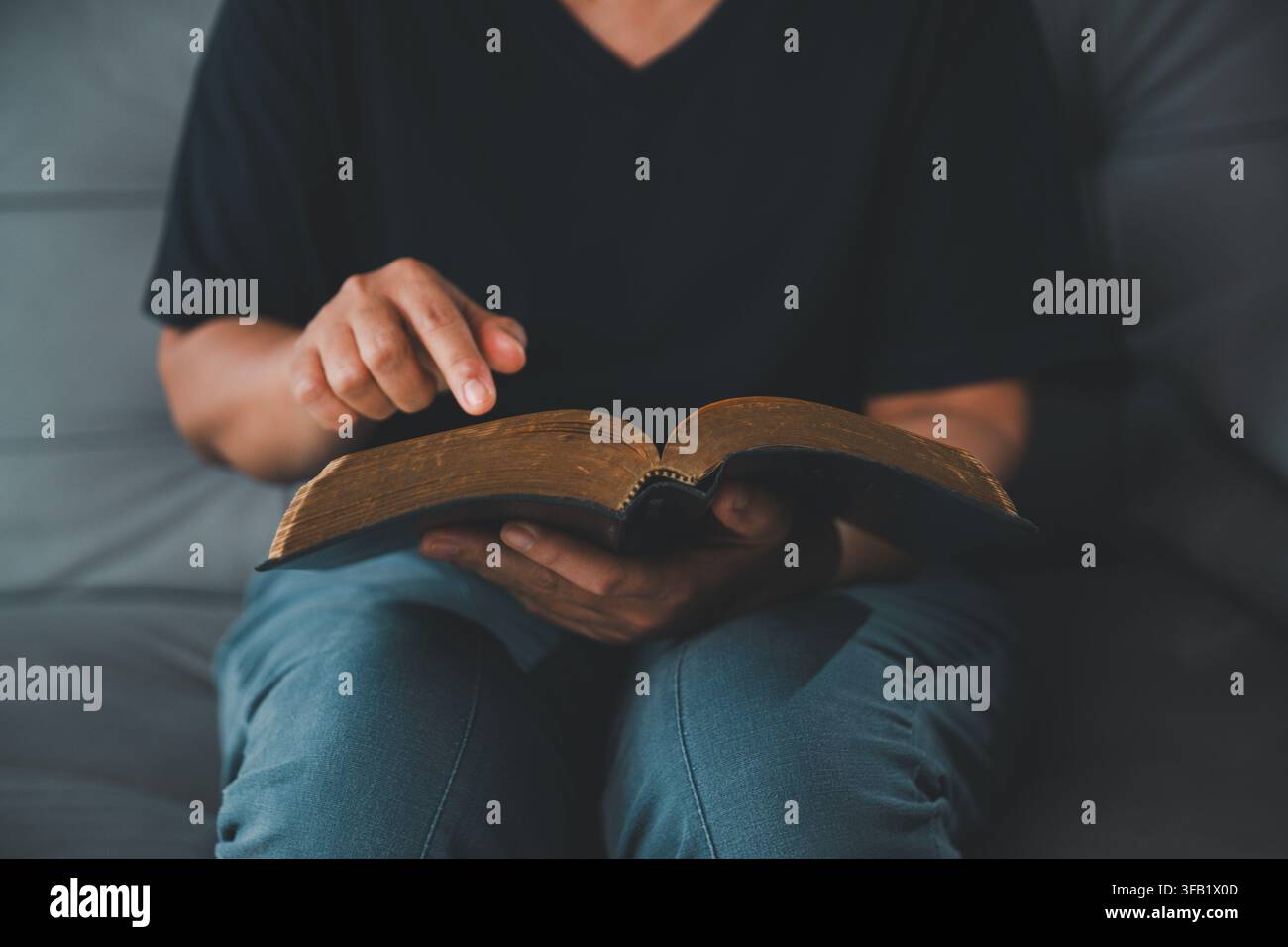 Gros plan d'une femme pointant un passage en lisant une ancienne Bible sur ses genoux, représentant la foi chrétienne, l'étude des Écritures, la dévotion, la sagesse Banque D'Images