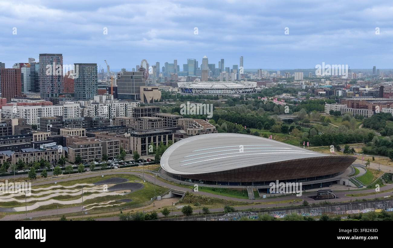 Vue aérienne du Queen Elizabeth Olympic Park avec le vélodrome, le London Aquatics Centre, des logements modernes et la ligne d'horizon lointaine de Canary Wharf. Banque D'Images