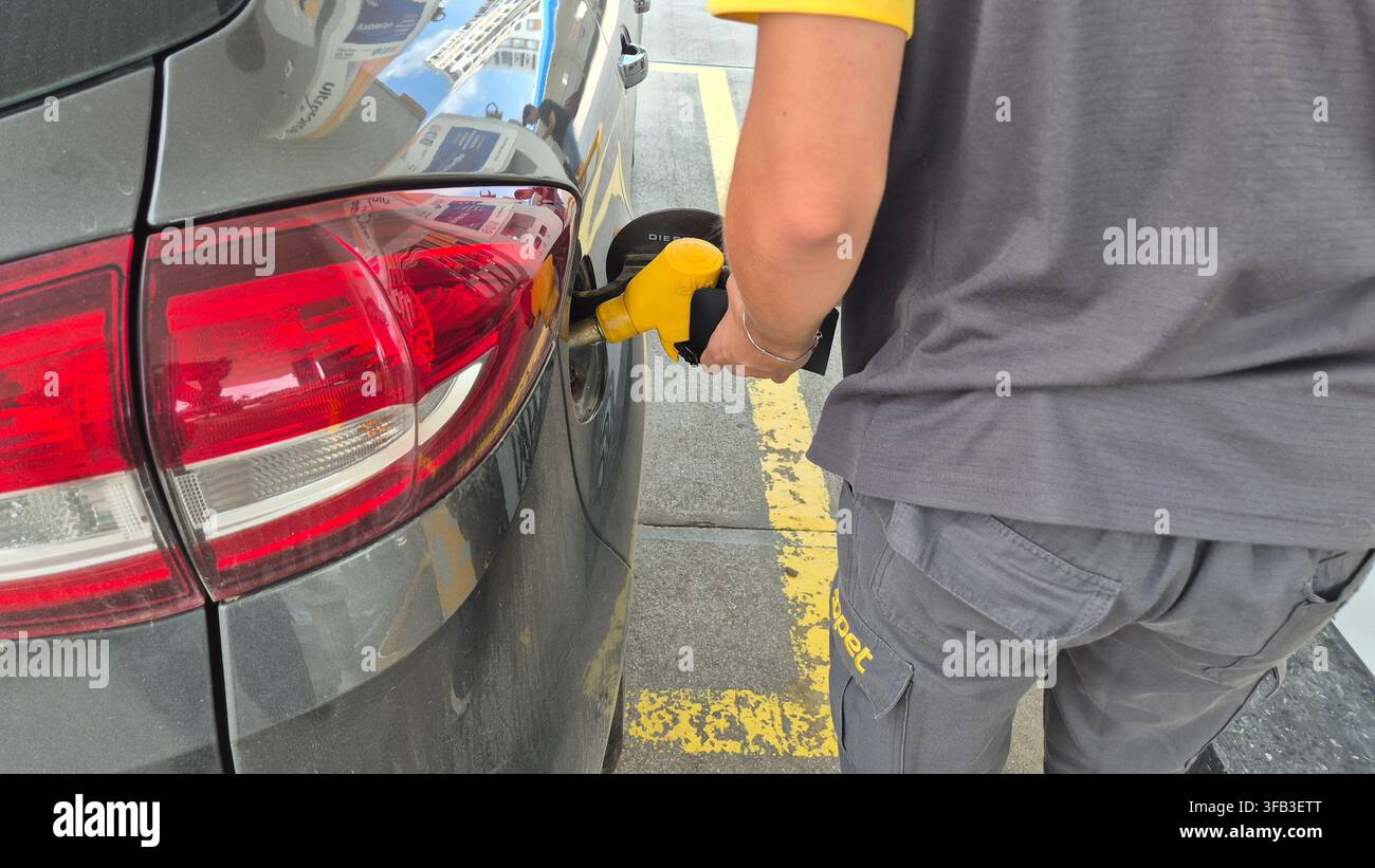 Voiture de ravitaillement avec buse de carburant jaune à la station-service gros plan - Image de stock capturée avec un smartphone