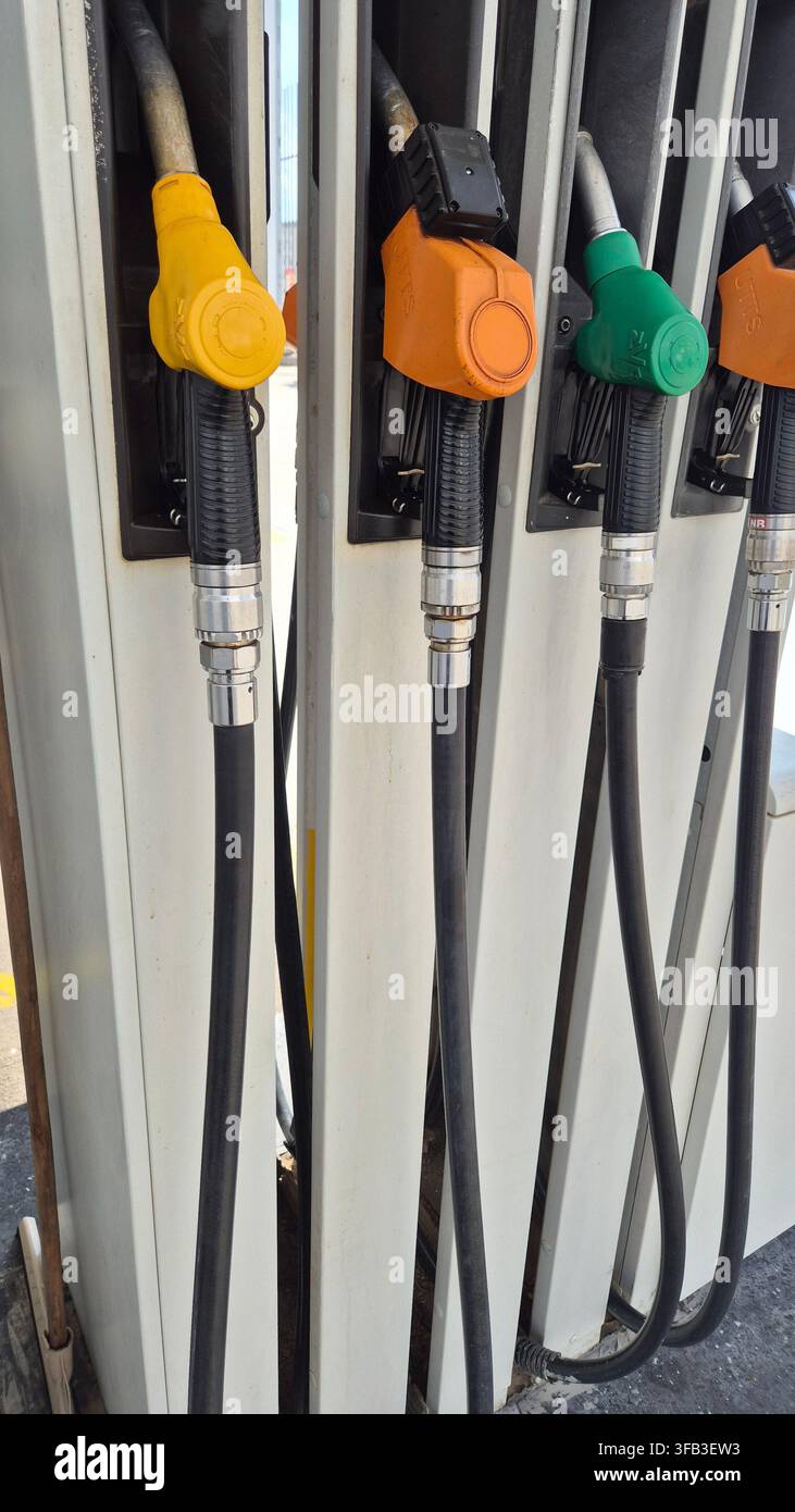Range de becs de distributeur de carburant colorés à la station-service - Image de stock capturée avec un smartphone