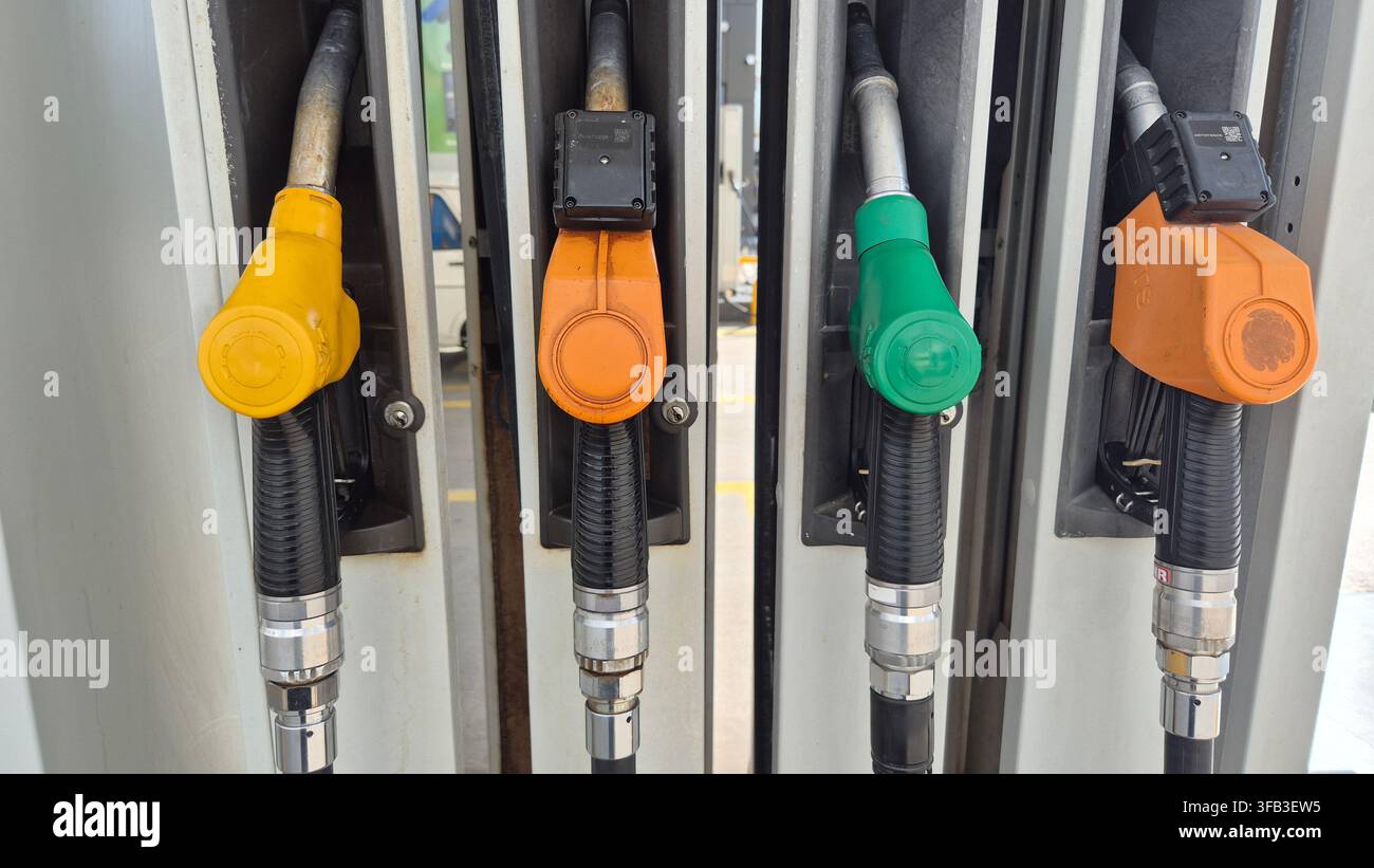 Range de becs de distributeur de carburant colorés à la station-service - Image de stock capturée avec un smartphone
