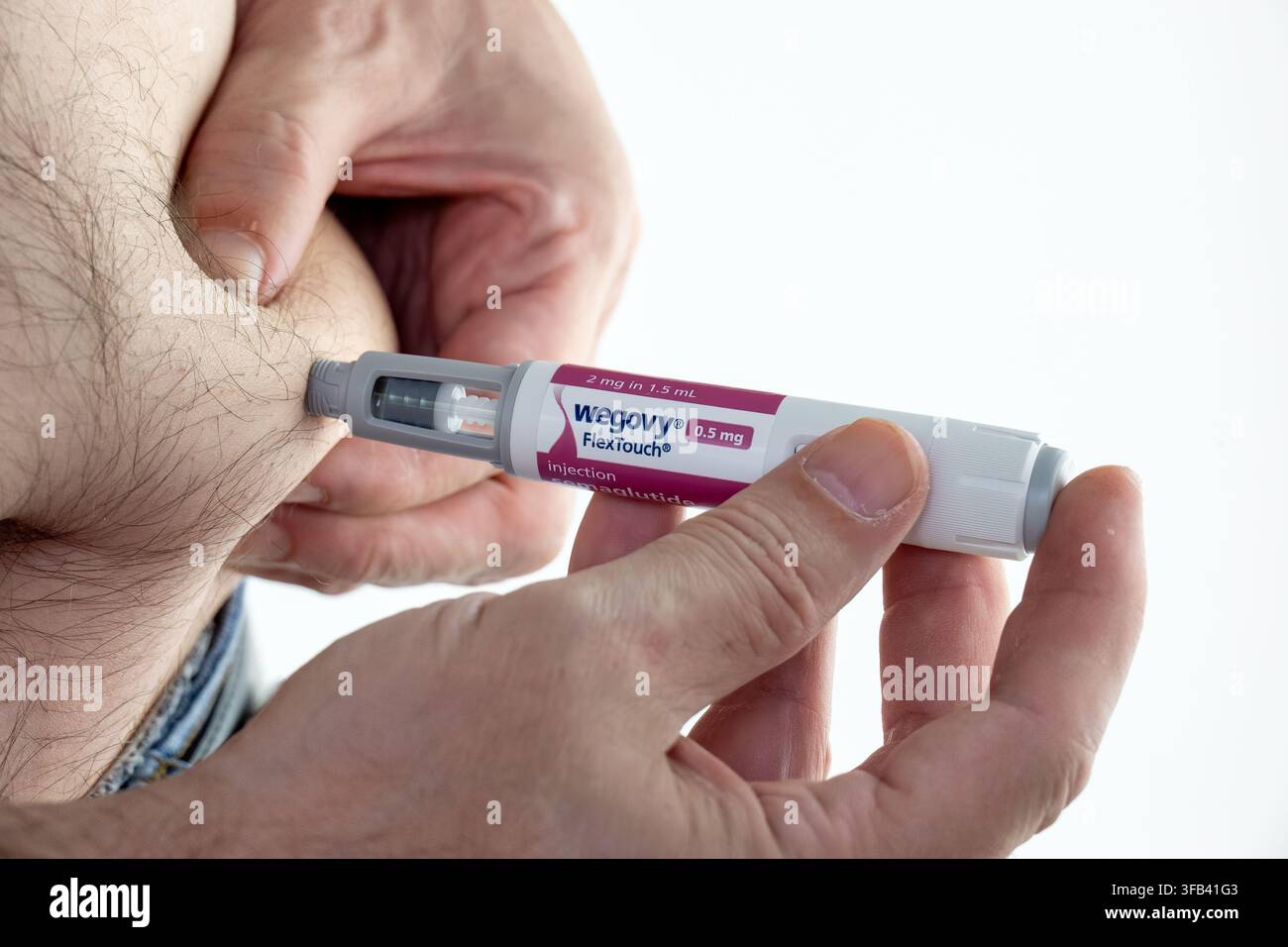 CHESTER, UK, 16 AOÛT 2026 : Une photographie en gros plan en studio d'une main tenant un stylo FlexTouch Wegovy (sémaglutide) de 1 mg pour administrer une subcu Banque D'Images