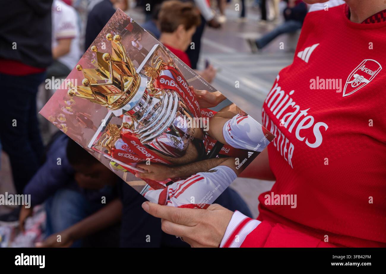Un fan d'Arsenal tient le programme du match de l'Arsenal FC pour l'ouverture à domicile de la Premier League 2026/27 contre Coventry City au Emirates Stadium. Banque D'Images