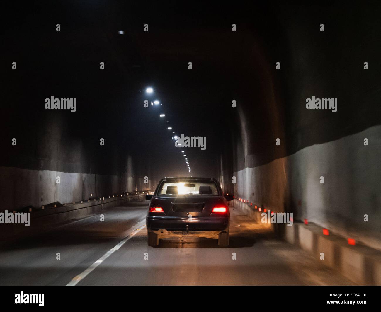 Une voiture traverse un long tunnel souterrain de l'autoroute M3 dans les montagnes de Bazumsky Ridge sous le col de Pouchkine dans la province de Lori en Arménie Banque D'Images