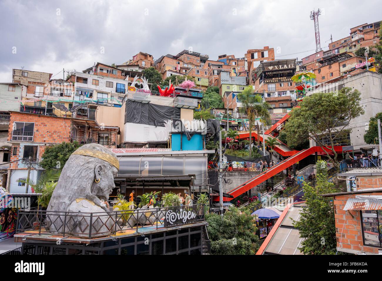 Medellín, Colombie – 15 janvier 2026 : la commune 13 de Medellín présente une art de rue coloré, une grande sculpture de tête indigène et des espaces publics animés Banque D'Images