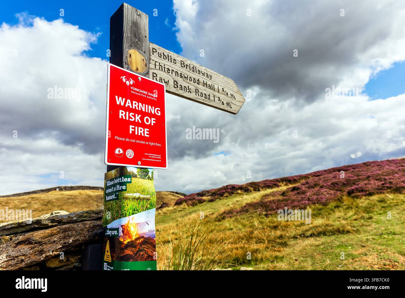 Panne d'avertissement d'incendie de forêt sur un terrain géré pour les tétras lyres à Swaledale, Yorkshire Dales, Royaume-Uni, à la fin de l'été. Des nuages d'orage dramatiques contrastent avec l'herbe sèche Banque D'Images
