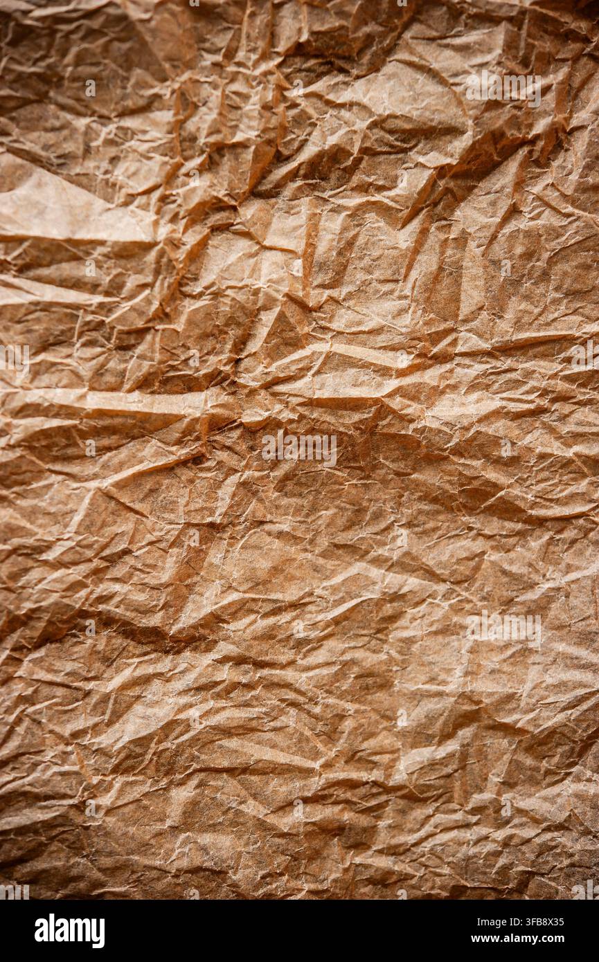 Grossissement de la texture du papier kraft brun froissé montrant des plis, des plis et une surface irrégulière en papier recyclé Banque D'Images