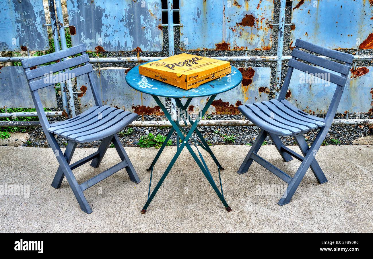 Boîte à pizza sur une table en métal bleu et des chaises pliantes en bois - Beaulieu-lès-Loches (37), France. Banque D'Images