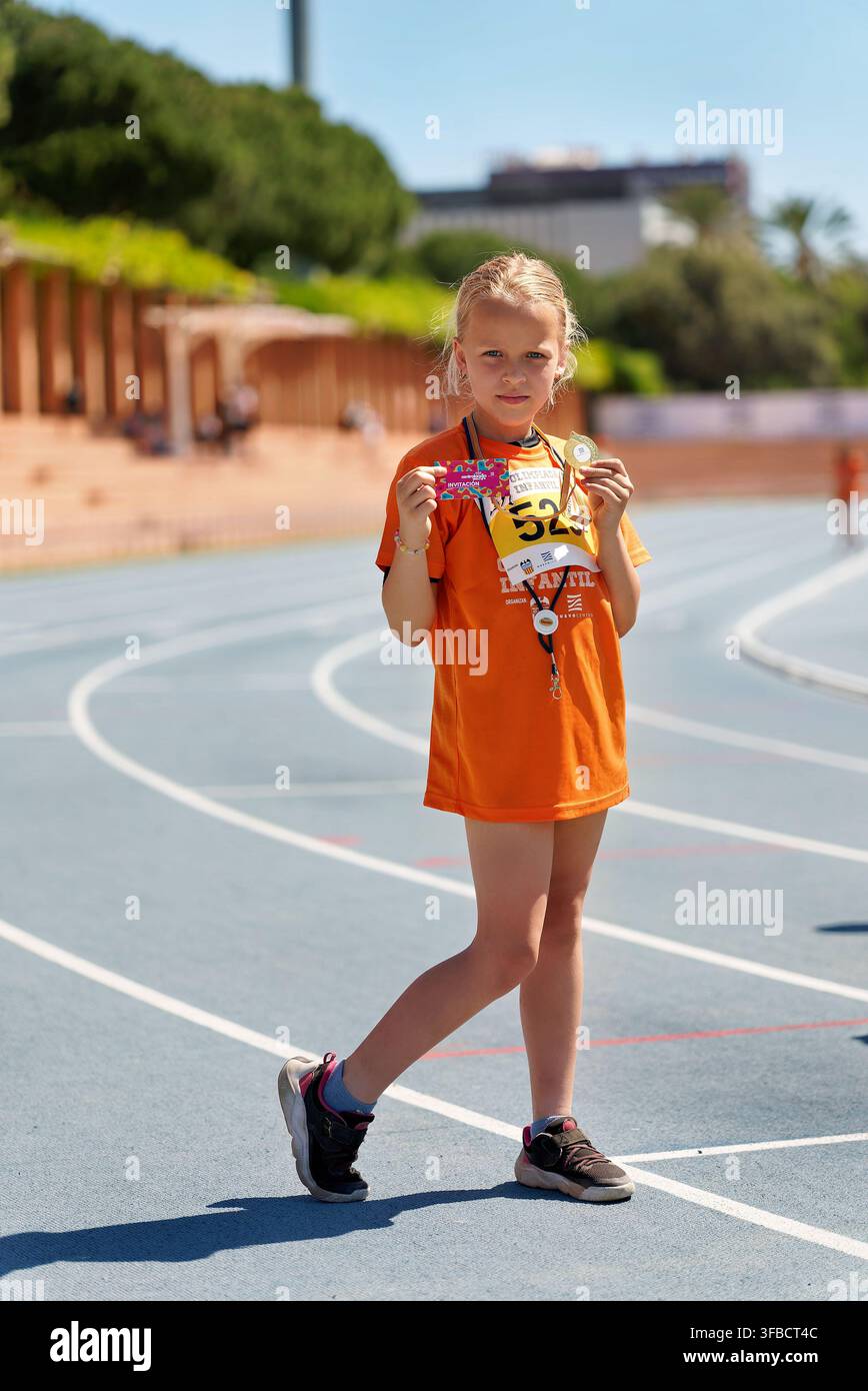 Fille avec une médaille sur la piste d'athlétisme lors d'une course pour enfants à Valence Banque D'Images