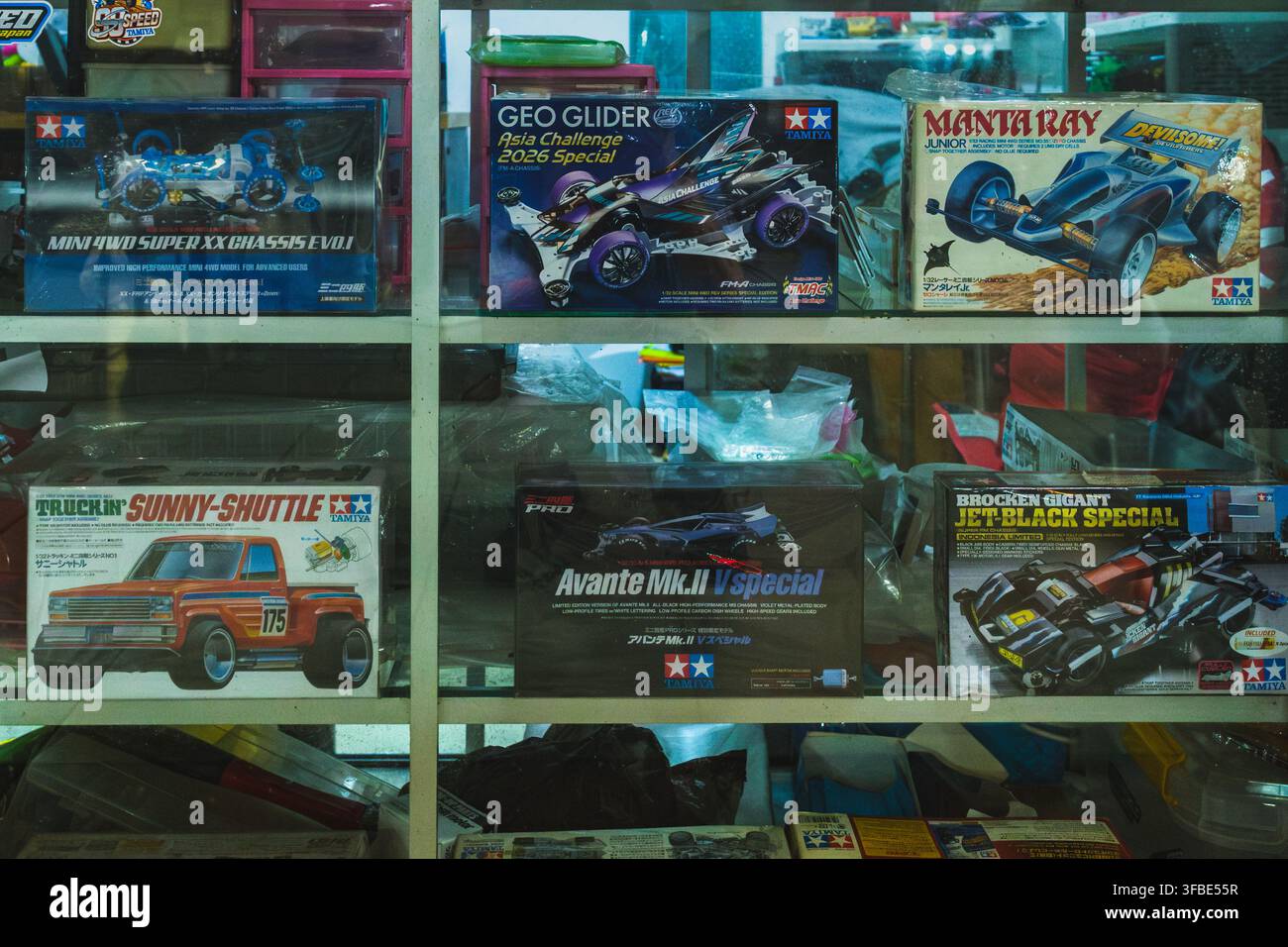 Balikpapan, Indonésie - 25 juillet 2026. Divers kits de modèles réduits de voitures Mini 4WD en boîte, disposés soigneusement sur une étagère en verre dans un magasin. Banque D'Images