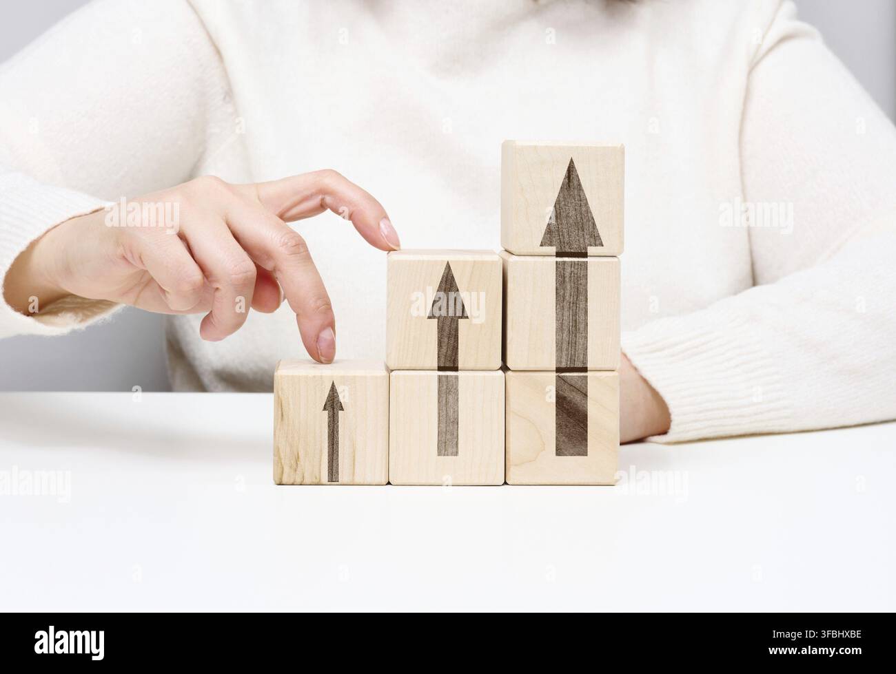 Pile de cubes en bois, les doigts de la personne montent les marches. Concept de croissance d'entreprise, réalisation des objectifs, auto-éducation, succès de carrière Banque D'Images