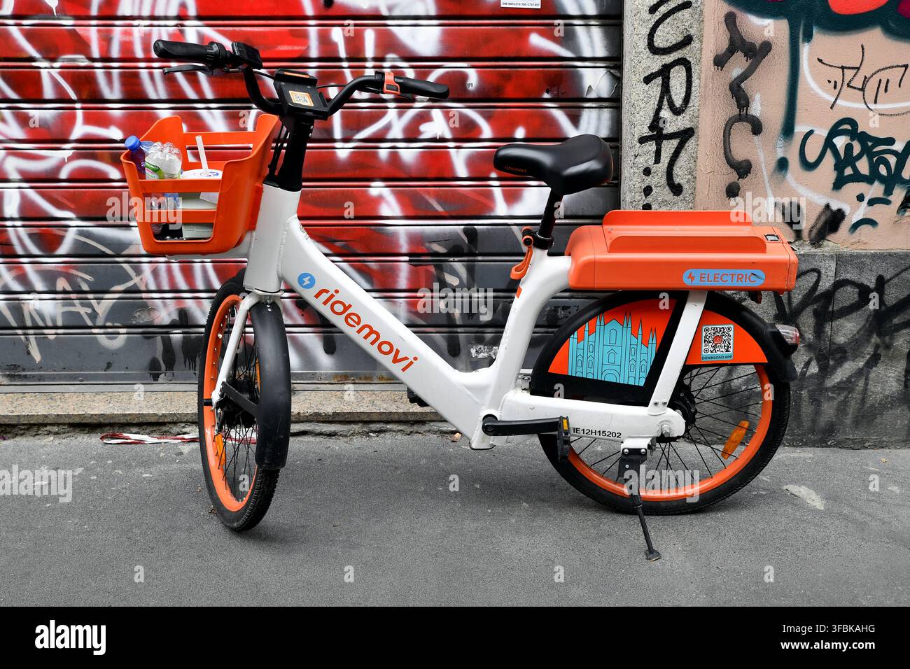 un vélo de location électrique RideMovi blanc et orange garé sur une rue de la ville - Milano - Italie Banque D'Images