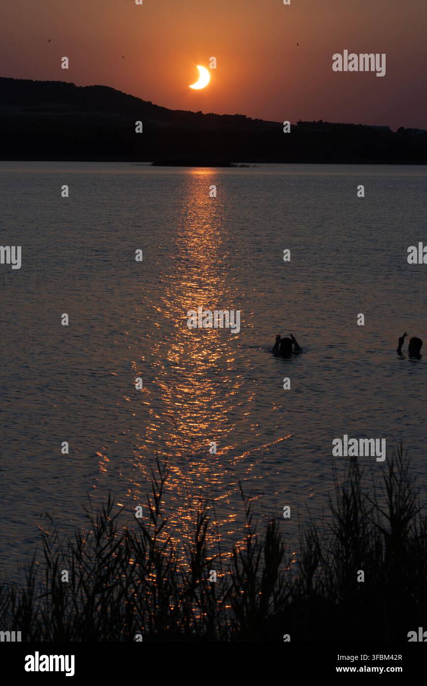 Éclipse solaire 2026 au coucher du soleil sur un paysage de lac et de montagne - Alcañiz - Espagne Banque D'Images