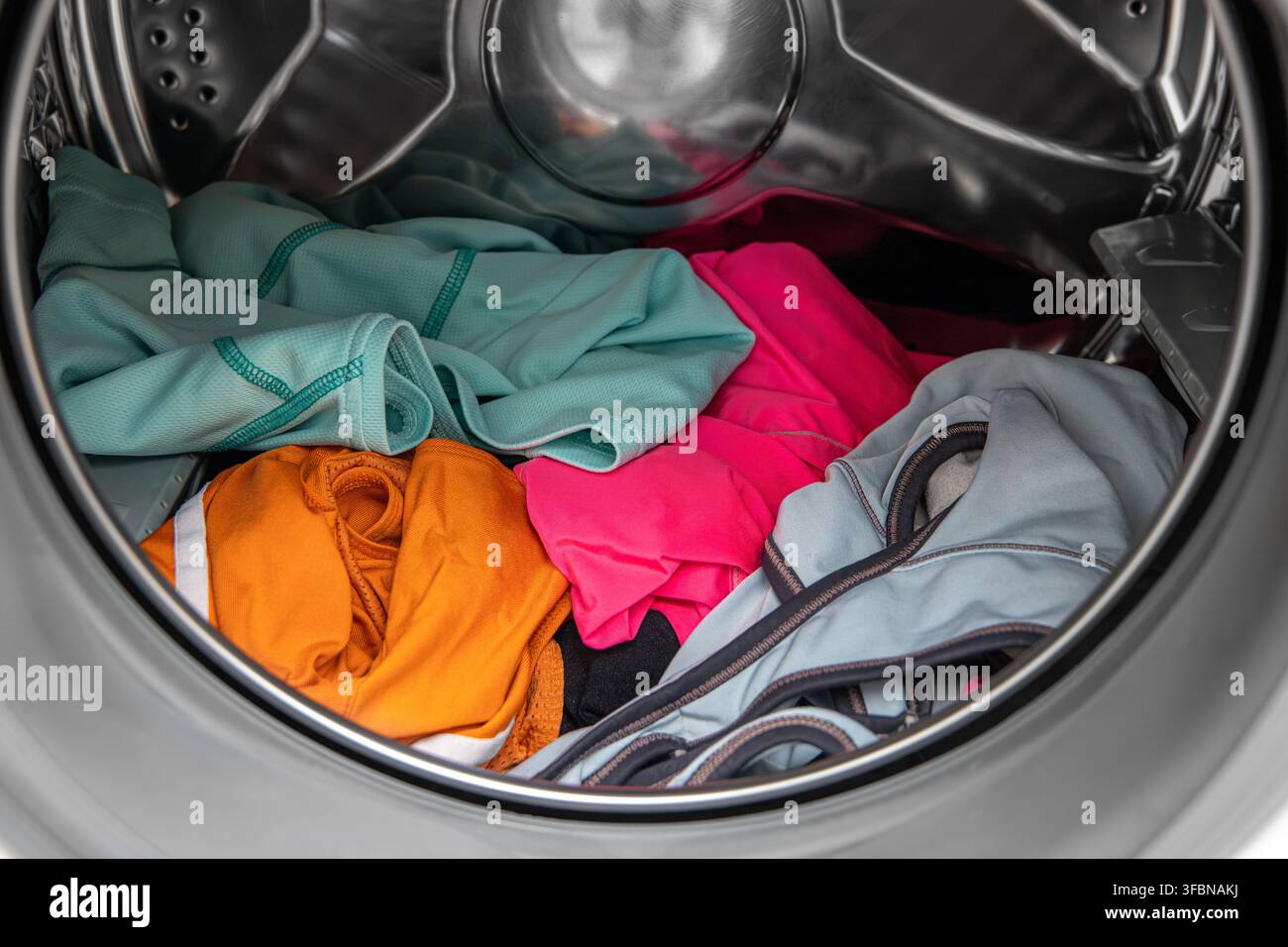 Vêtements de sport usagés et sales dans une machine à laver  un concept de linge de sport à laver. Banque D'Images