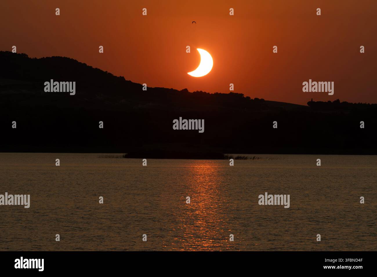 Éclipse solaire 2026 au coucher du soleil sur un paysage de lac et de montagne - Alcañiz - Espagne Banque D'Images