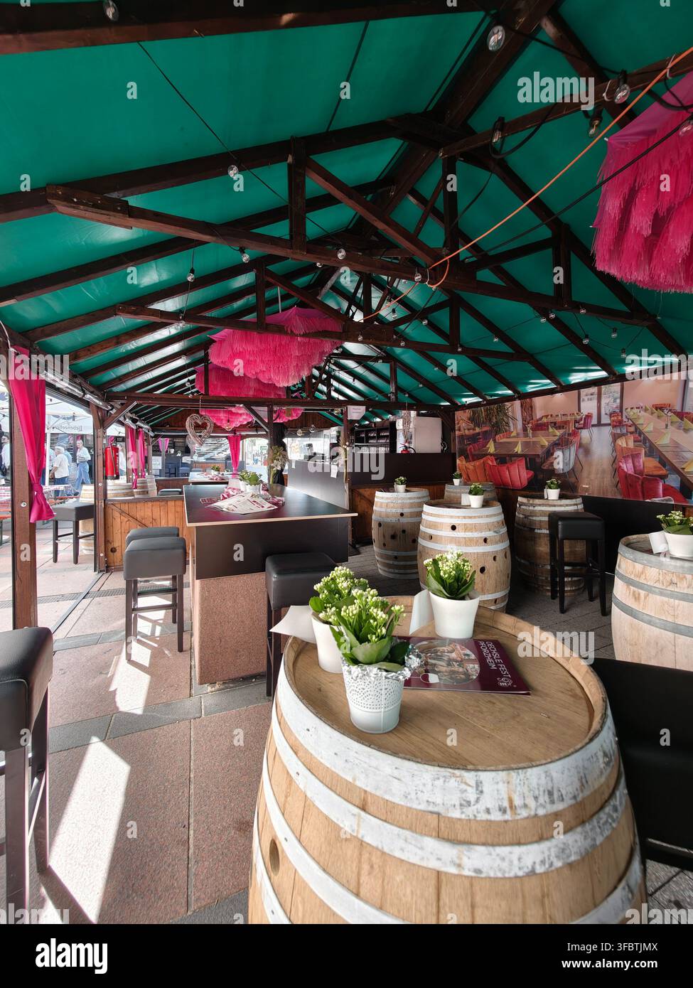 Pforzheim Allemagne 23 août 2026 Festival Oechsle Pforzheim Terrasse de restaurant extérieure couverte avec des tables en tonneau en bois, des tabourets hauts, une longue table commune Banque D'Images