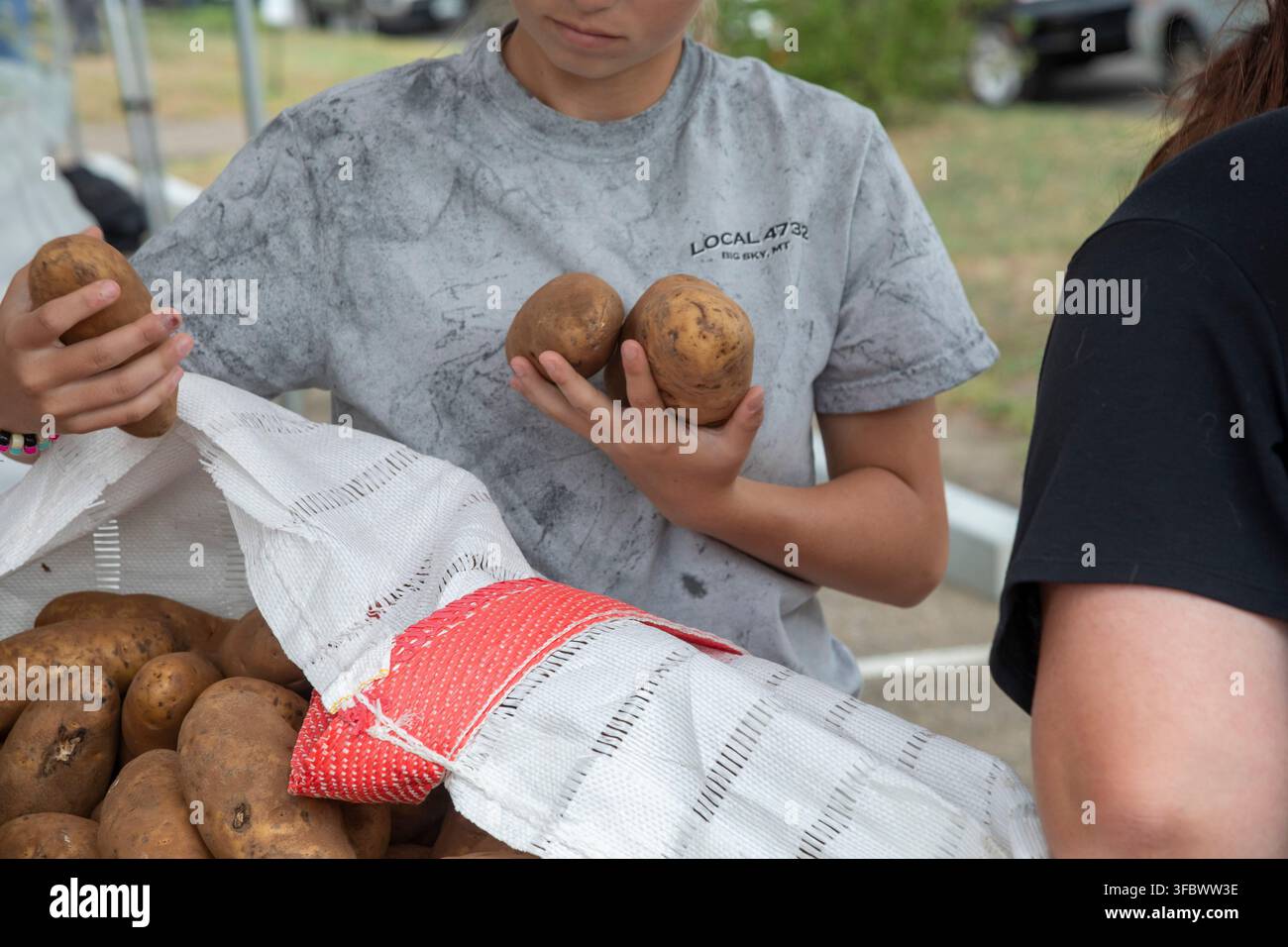 Denver, Colorado – L'organisation à but non lucratif We Don't Waste distribue 21 tonnes de pommes de terre excédentaires aux résidents de la région. L'organisation recueille des denrées alimentaires qui ser Banque D'Images