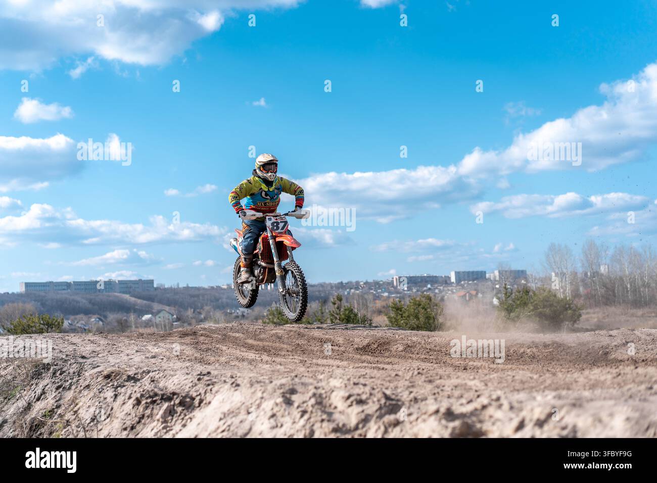 Kharkov Ukraine le 03 mars 2021 Kharkov Ukraine en mars 2021 Un pilote s'entraîne sur une moto enduro sur une piste hors route. Le ciel est dégagé et le pilote saute par-dessus une bosse de terre. Banque D'Images