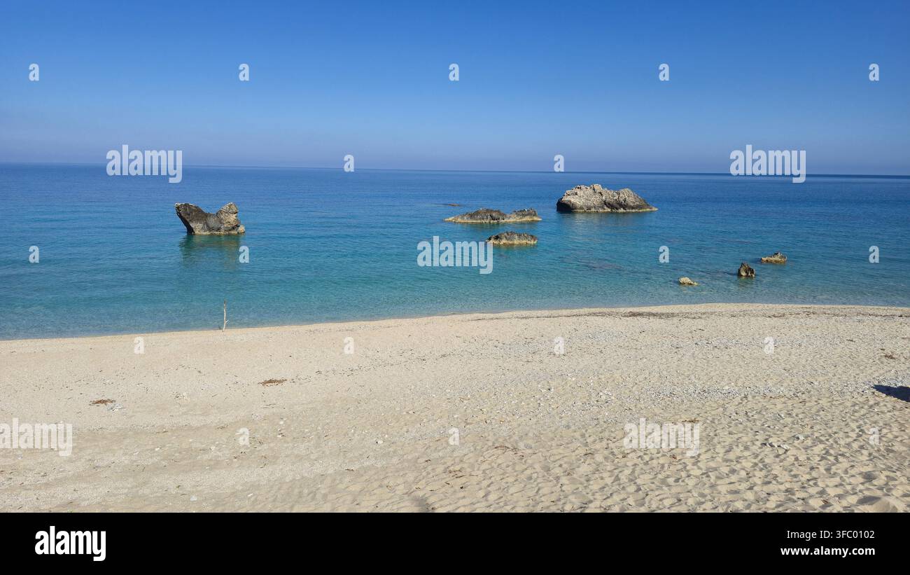 Plage de Gaidaros, située à Kalamitsi, Lefkada, Grèce, présente des sables dorés doux et des eaux cristallines. Cet endroit serein invite à la détente au soleil, entouré d'une beauté naturelle époustouflante. Banque D'Images
