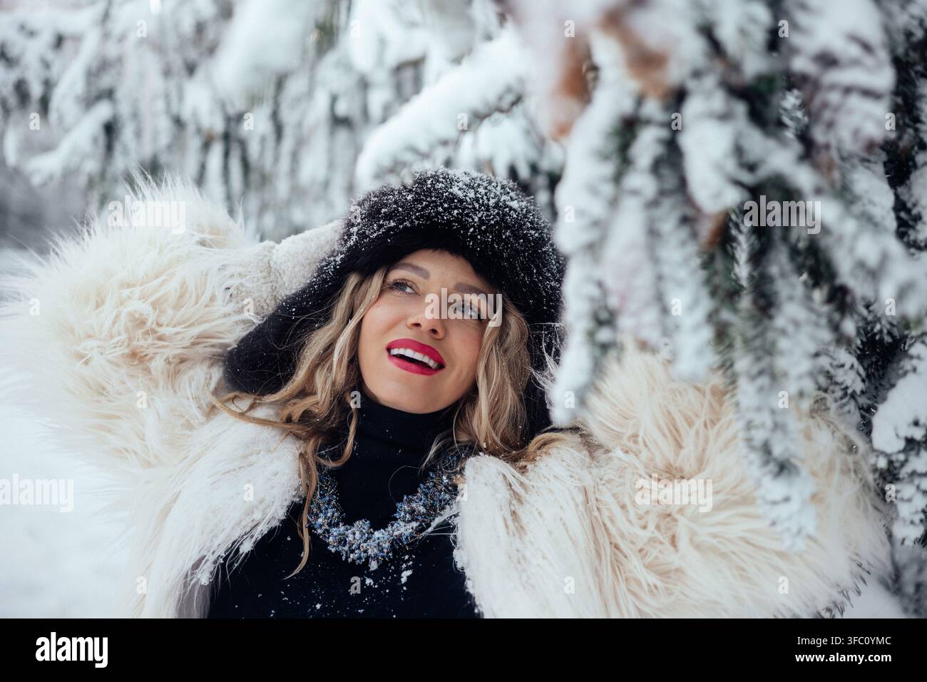 Sortie hivernale avec une femme profitant de la neige dans une forêt sous des arbres couverts de neige Banque D'Images
