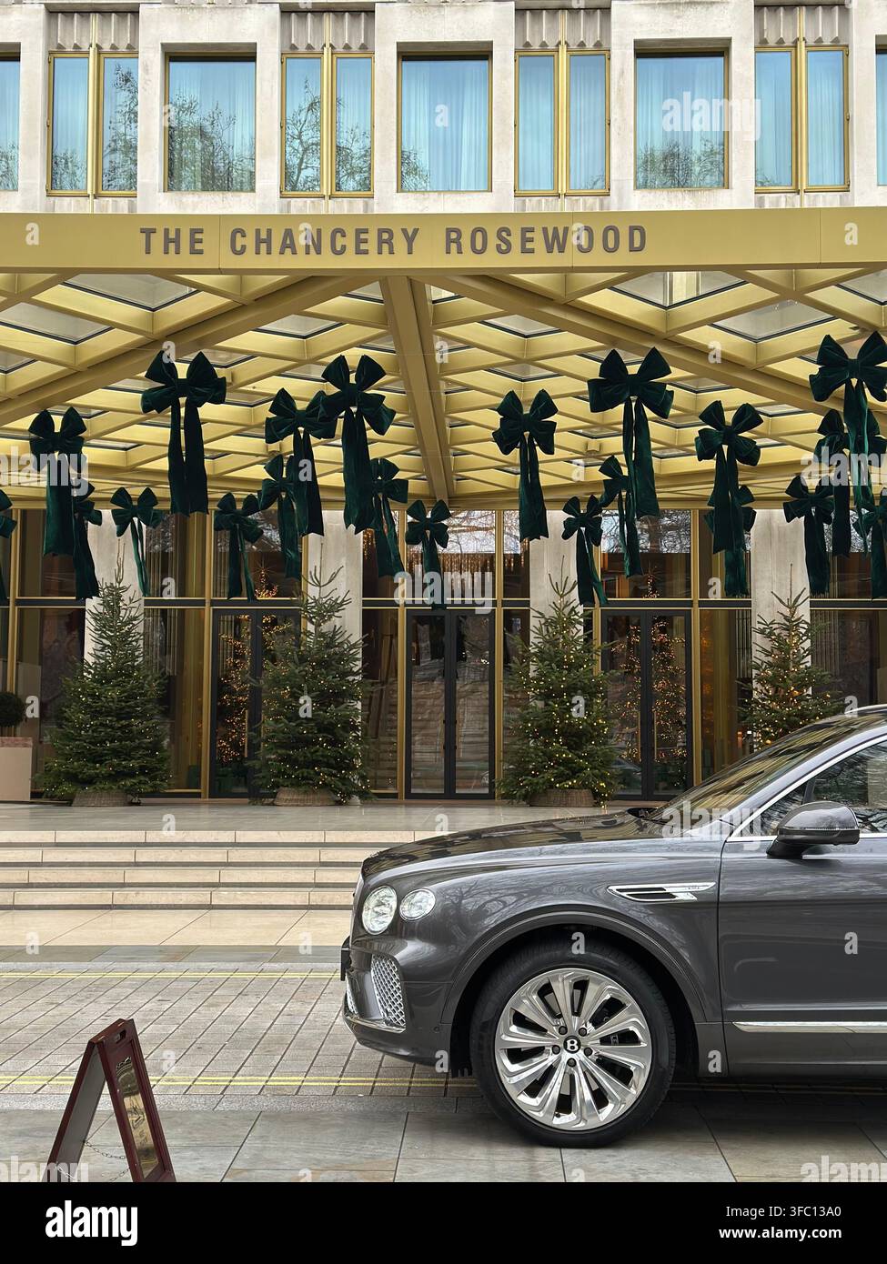Décorations de Noël pour l'entrée des vacances à l'hôtel The Chancery Rosewood à Londres, avec une Bentley grise garée devant - Image de stock capturée avec un smartphone