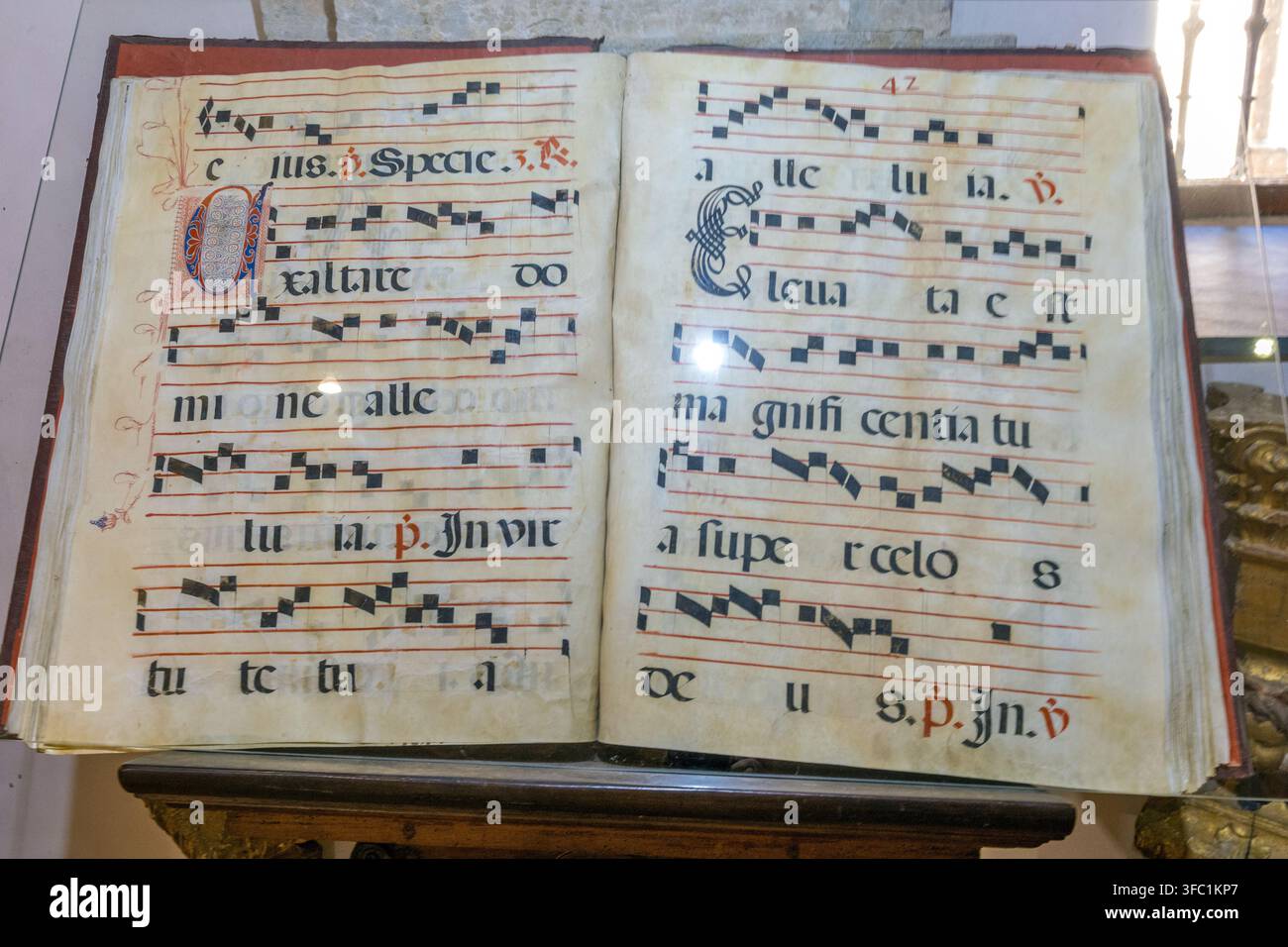 Un manuscrit liturgique ancien ouvert avec des notations musicales manuscrites et des lettres gothiques repose sur un support dans un musée en Espagne. Banque D'Images
