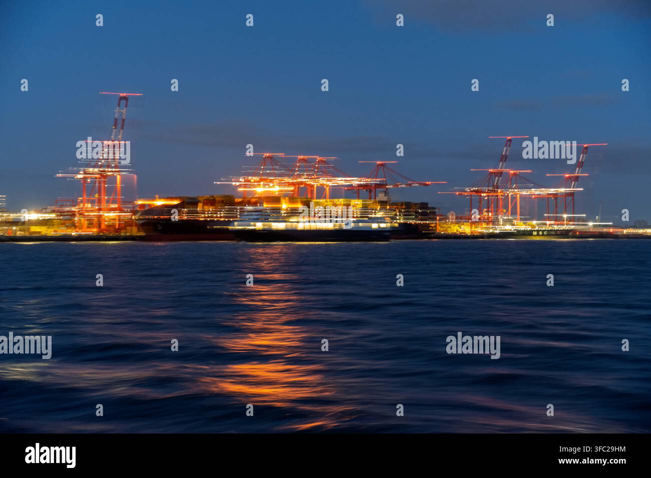 Terminal de conteneurs de Seaforth la nuit sur la rivière Mersey avec un mouvement délibéré sur l'image pour l'effet. Banque D'Images