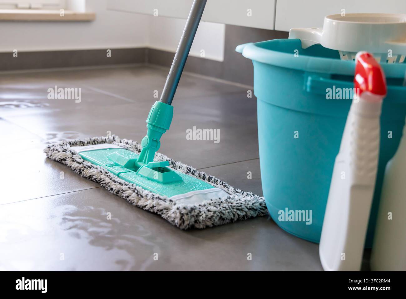 Une vue rapprochée d'un balai et d'un seau avec des bouteilles de spray de nettoyage prêtes pour les tâches ménagères Banque D'Images