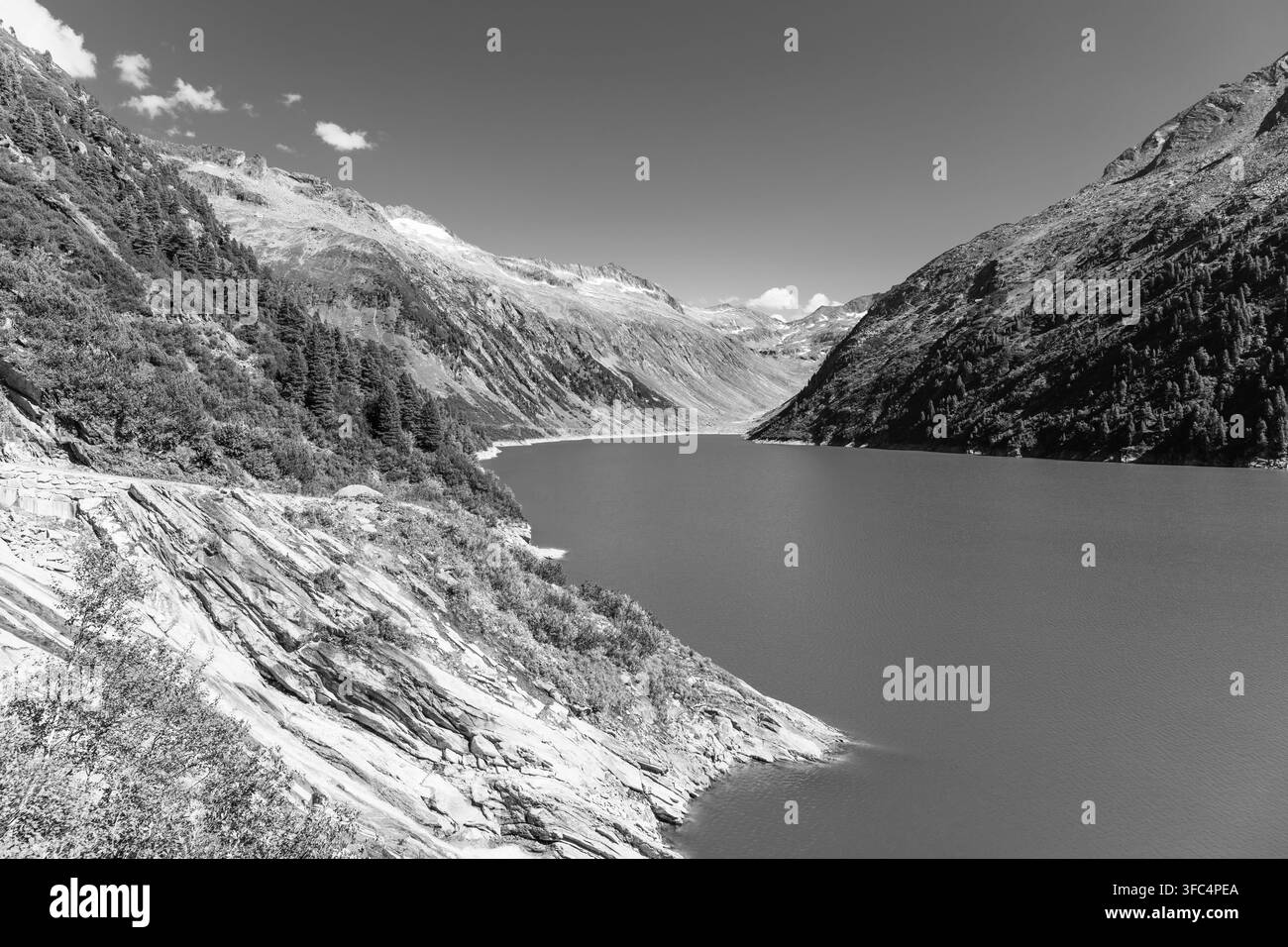 Belle vallée alpine avec l'eau bleu azur du barrage de Speicher Zillergrundl, Alpes de Zillertal, Autriche. Photographie noir et blanc Banque D'Images