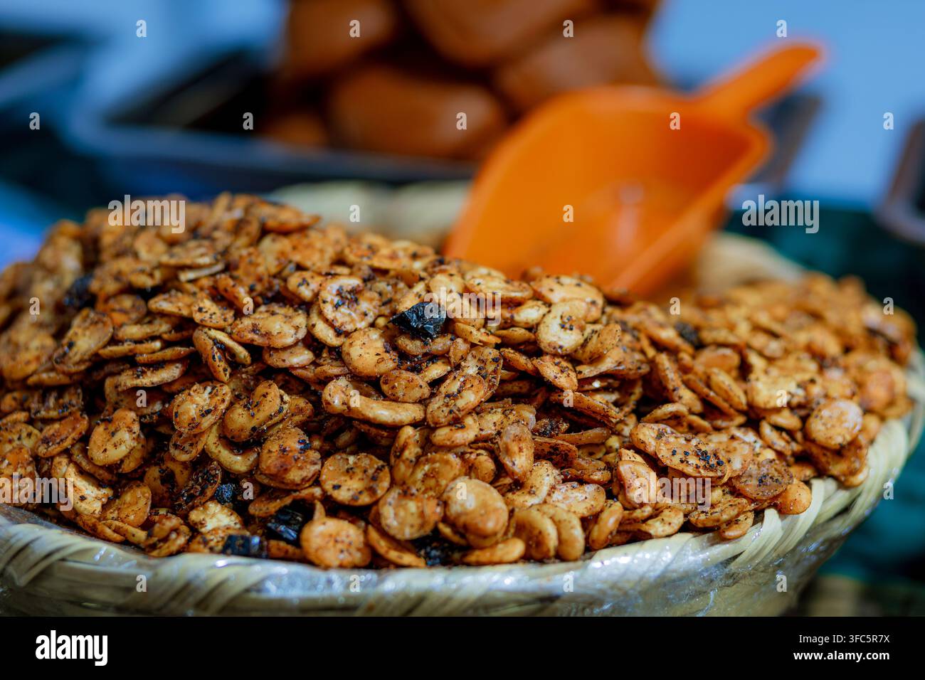 Fèves rôties croustillantes assaisonnées au chili servies dans un panier tressé avec une cuillère, parfaites pour les encas traditionnels, la cuisine mexicaine et la rue Banque D'Images