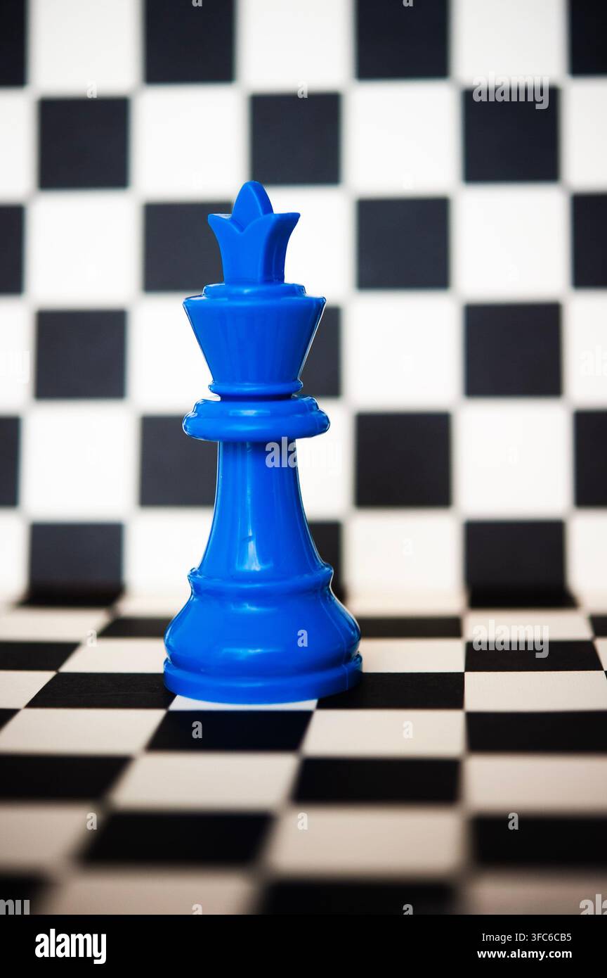 Pièce d'échiquier bleu roi debout sur un échiquier noir et blanc, un concept audacieux de stratégie, de pouvoir, de leadership et de prise de décision Banque D'Images