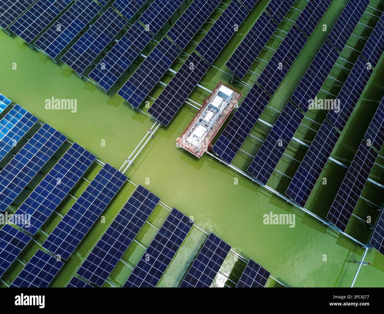 Vue aérienne du parc solaire de 68 MW de Sirajganj avec des rangées de panneaux solaires flottants installés sur l'eau verte à Sirajganj, division de Rajshahi, Bangladesh. Banque D'Images