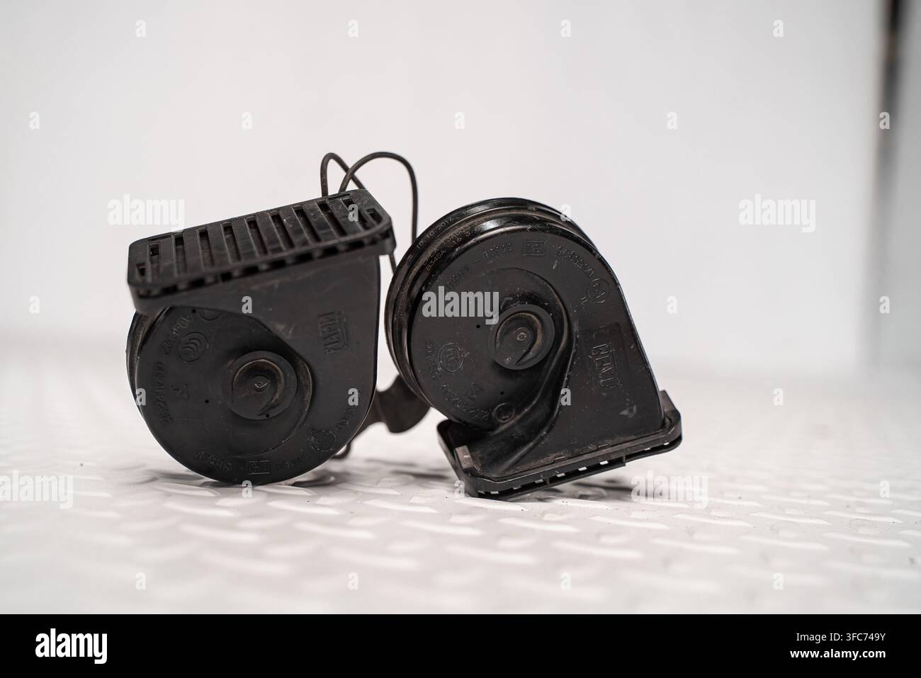 Une paire de klaxons d'avertissement électriques pour automobiles avec câblage est isolée sur un fond studio blanc. Banque D'Images