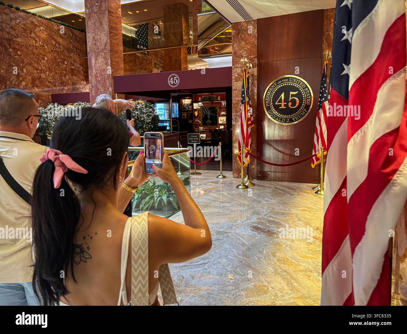 Un visiteur photographie le sceau présidentiel marquant le premier mandat de Donald Trump, à l'entrée du bar 45 Wine and Whiskey dans le Trump Tower. New York Banque D'Images