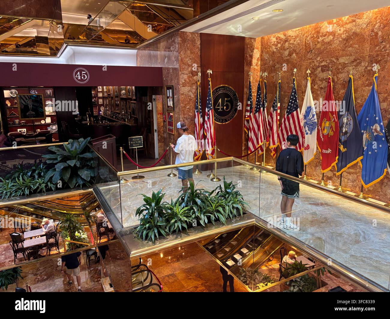 Le bar 45 Wine and Whiskey et sa rangée de drapeaux américains et militaires, vus depuis un niveau supérieur de l'atrium du Trump Tower. New York, New York, États-Unis Banque D'Images