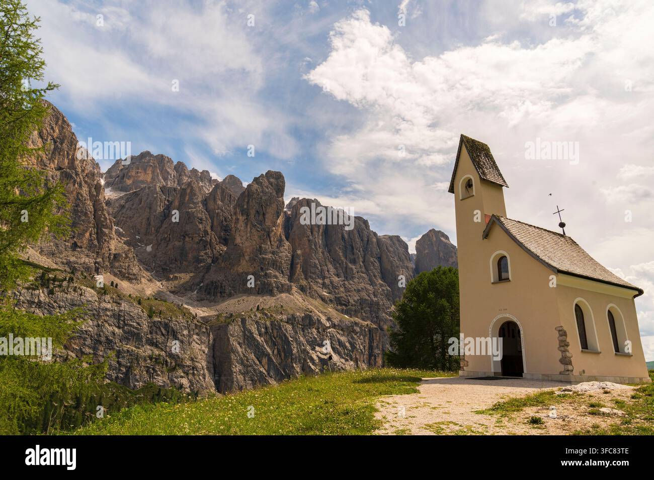 La chapelle San Maurizio nichée au col du Gardena avec les imposantes murailles des Dolomites en arrière-plan. Banque D'Images