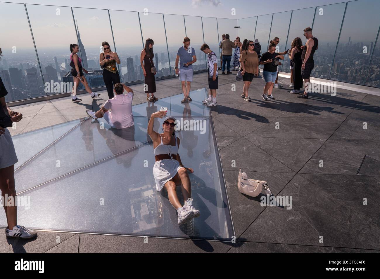 Un visiteur est allongé sur le sol vitré du pont pour prendre un selfie. New York, New York, États-Unis, 7 août 2026. Banque D'Images