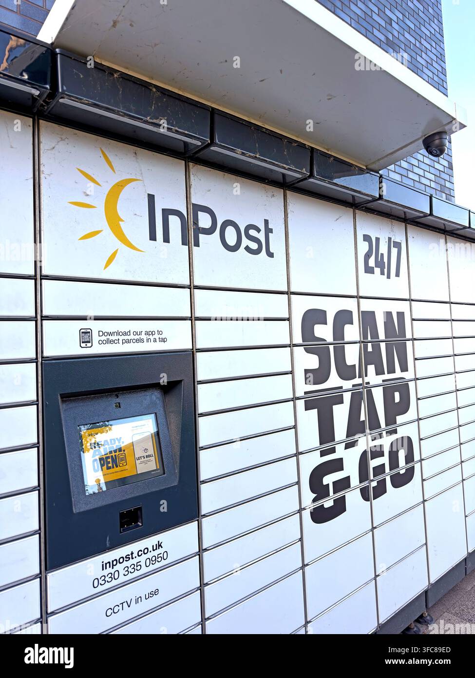 Colis automatisé InPost blanc avec marque Scan, Tap & Go, illustrant la livraison et les retours à l’extérieur du domicile. Banque D'Images